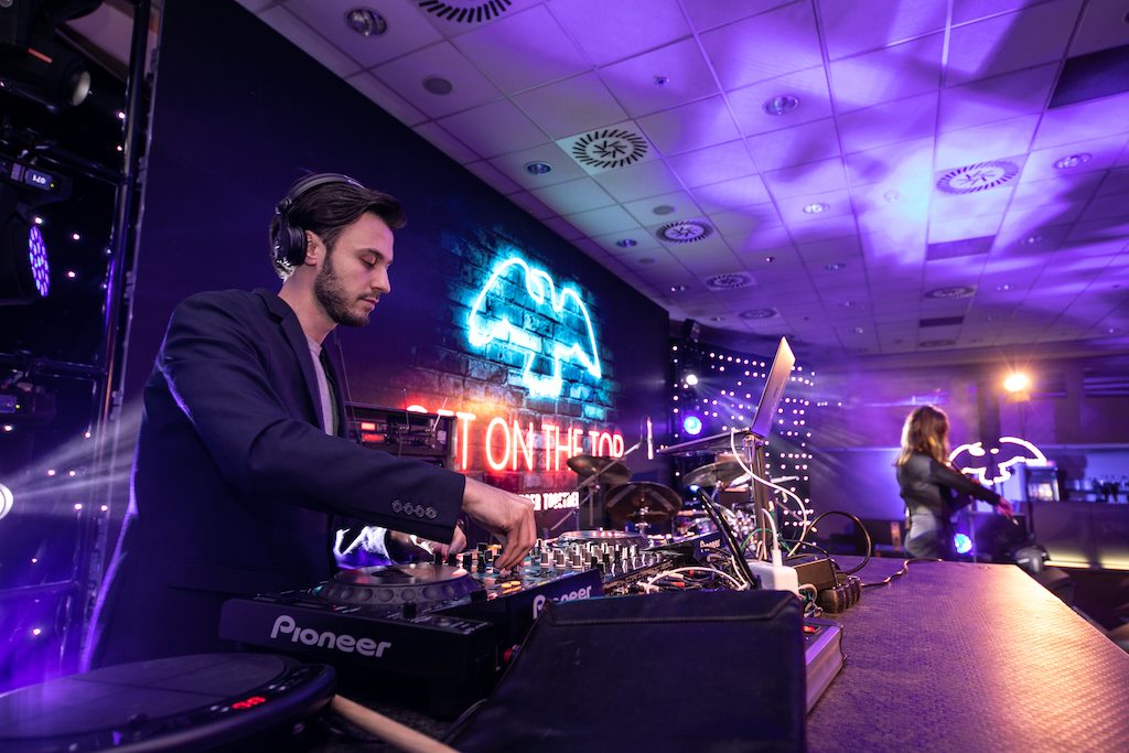 DJ Bury hraje za DJ pultem na firemním večírku PepsiCo